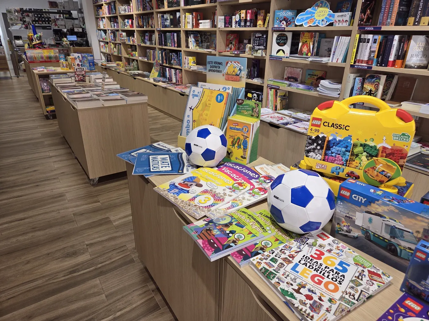 Mesa con cuadernos de vacaciones, juegos y libros infantiles